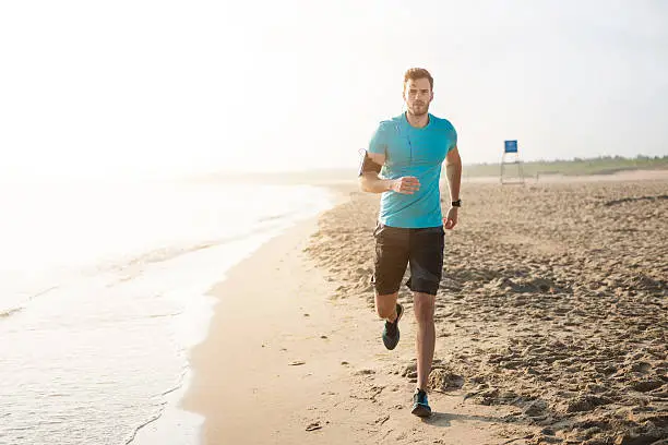 Photo of Handsome man running on the beach
