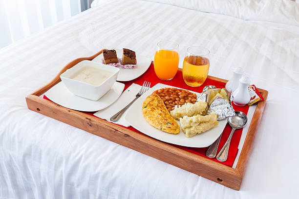 istock Breakfast set  in wooden tray serving on bed 576584410