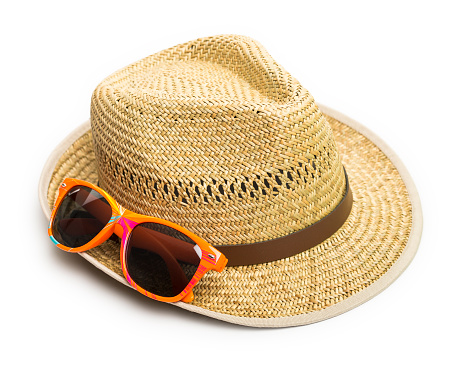 A simple straw hat for male coupled with an orange pair of sunglasses are nicely isolated on a pure white background; close up studio shot for beach and vacations purposes.