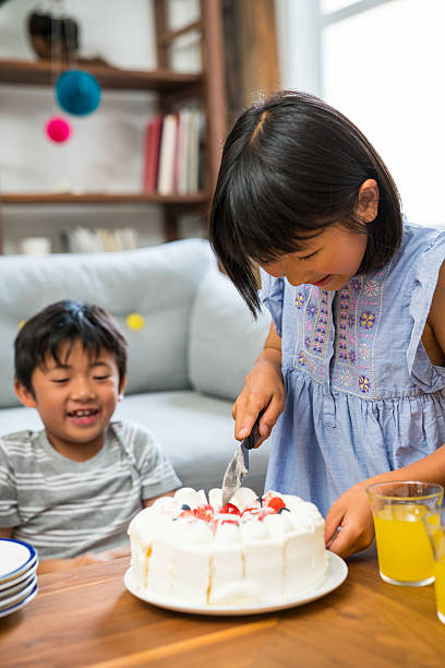 istock Boy watches sister cut birthday cake 576592712