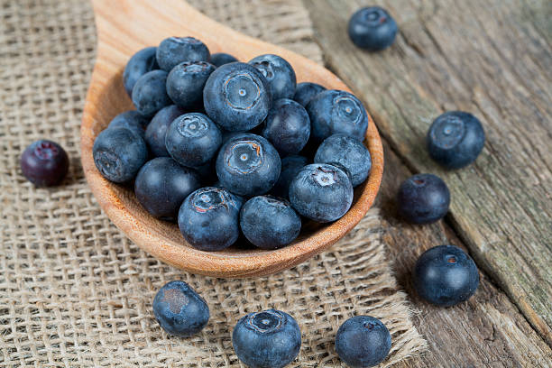 istock fresh blueberries in a wooden spoon over wooden table 576594174