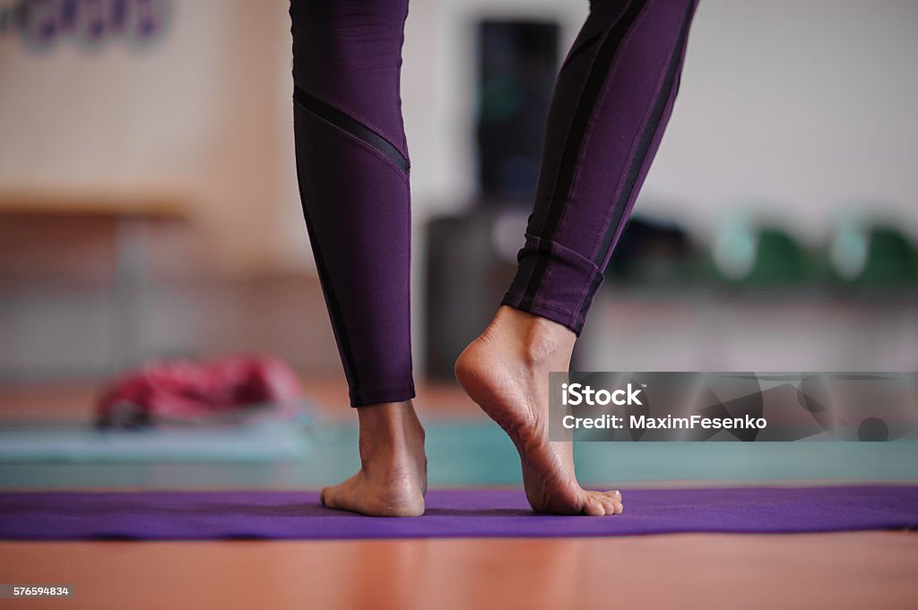 woman standing at yoga class woman standing barefoot at yoga class. no face Yoga Stock Photo