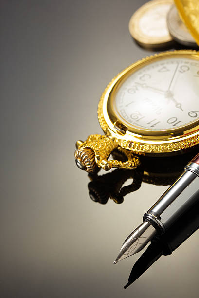 istock pocket watch and ink pen on black 576595404