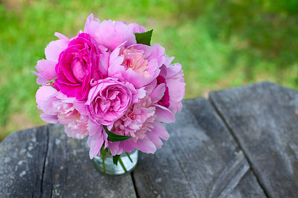 istock peony and rose bouquet on wooden surface 576597970