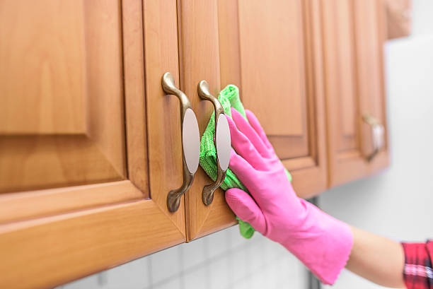 istock Women's gloved hand wipe the dust from the locker 576598384