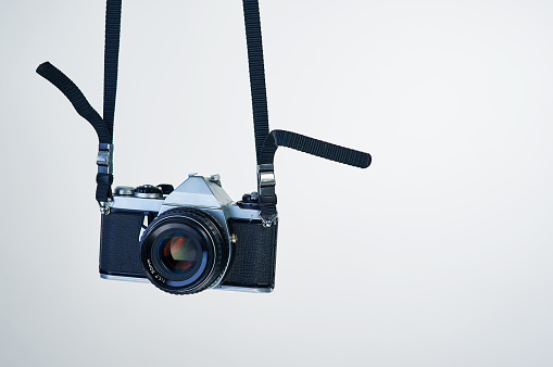 Studio shot of a camera hanging by its strap