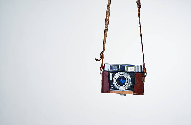 Film or nothing Studio shot of a camera hanging by its strap animal skin flash stock pictures, royalty-free photos & images