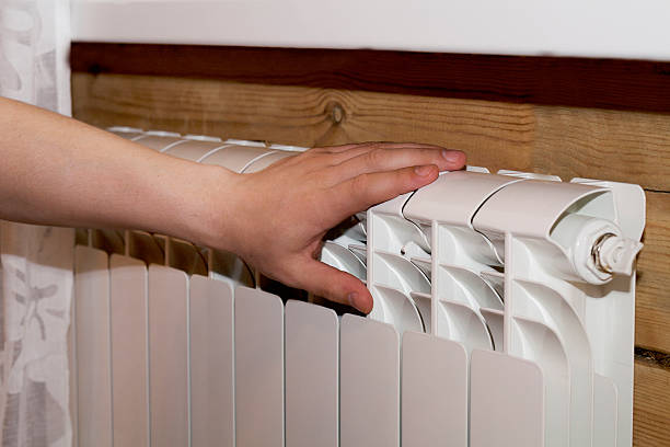 istock couple warm up hands over heater 576604740