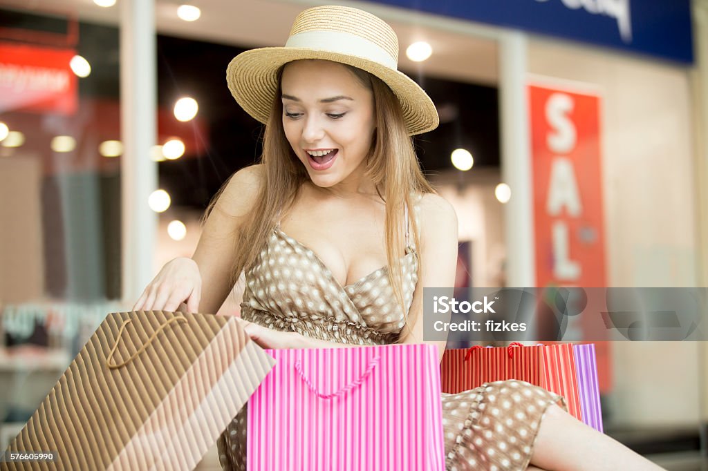 Glückliche Shopping-Frau schaut auf ihren Kauf - Lizenzfrei Aufregung Stock-Foto