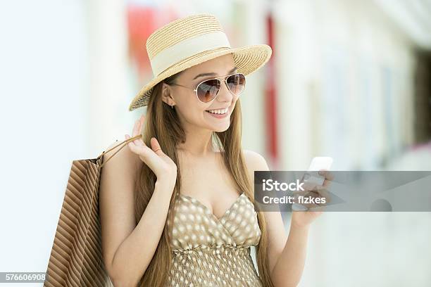 Woman In Shopping Centre Looking At Mobile Phone Stock Photo - Download Image Now - Retail, Shopping, Smart Phone