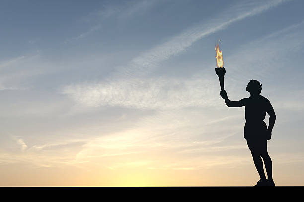 istock Athlete holding a flaming torch silhouette 576711844