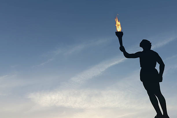 istock Athlete holding a flaming torch silhouette 576711846