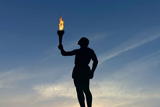 istock Athlete holding a flaming torch silhouette 576711860