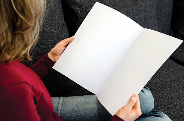 frau schaut auf ein leeres magazin mit kopierraum - newspaper reading holding paper stock-fotos und bilder