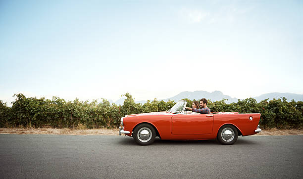 Pack the car, the road awaits Shot of a young couple out on a road trip in a vintage convertible convertible stock pictures, royalty-free photos & images