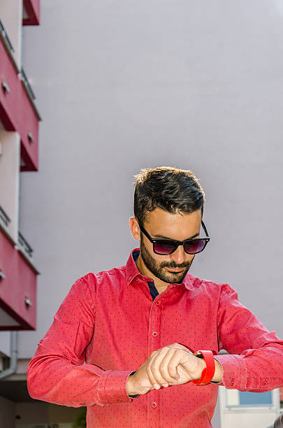 istock business man in a red shirt utilizes a smart watch 576715198
