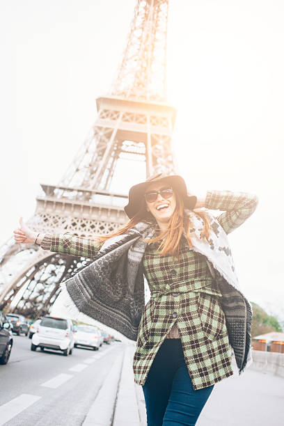 istock Young woman with thumb up for hitch-hiking at Eiffel tower 576715244