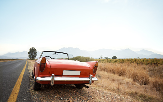 Shot of a vintage car parked on the side of the road