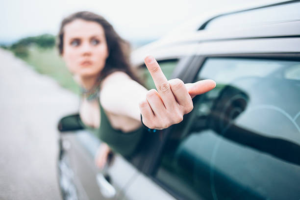 istock Young woman making obscene gesture on road 576715564