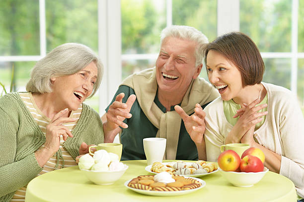 istock daughter with senior parents drinkig tea 576716260
