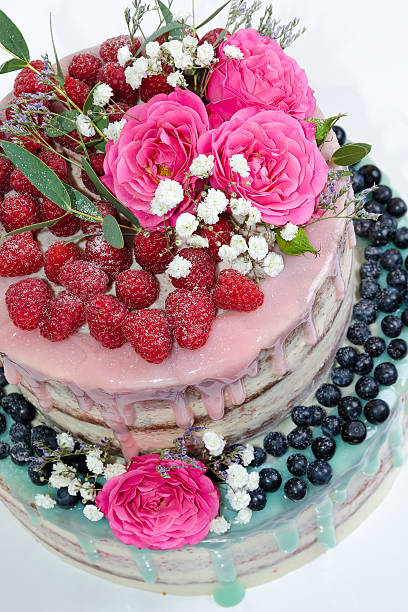 istock wedding color drip cake with roses, blueberries and  raspberries 576719372