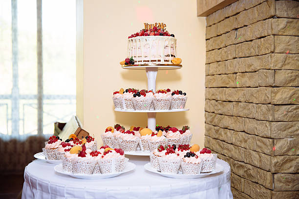 istock Sweet multilevel wedding cake decorated with flowers. Candy bar 576721140