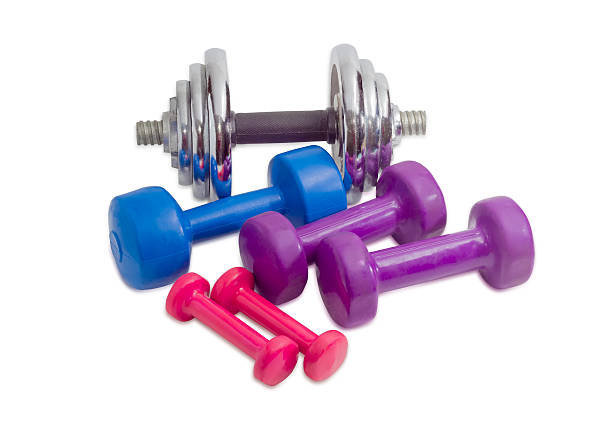 istock Several dumbbell different colors, weight and sizes on light bac 576721412