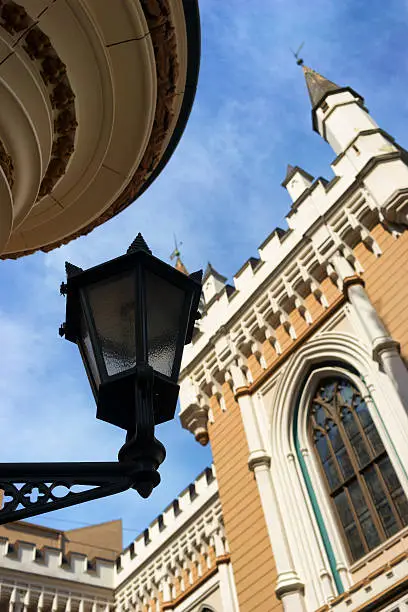 Street lamp in the afternoon on a background of the ancient buildings of the Guild and the blue sky in the old town of Riga