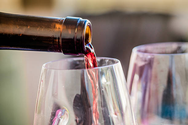 Close-up shot while red wine being poured in a wine glass.