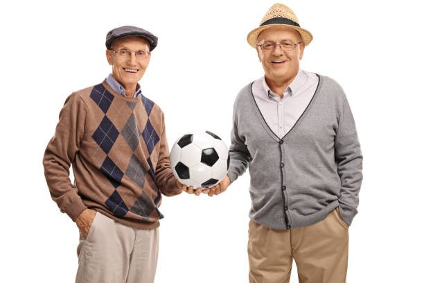 istock Two elderly friends holding a football 576725346
