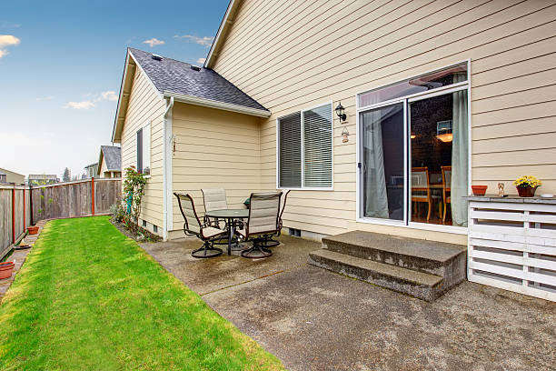 istock Backyard area with patio table set. Beige house exterior. 576726414