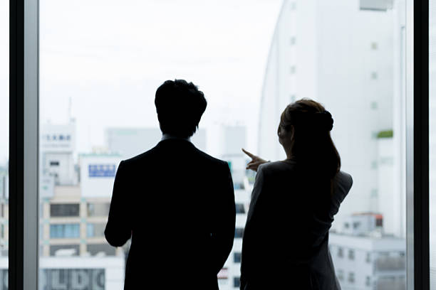 istock Men and women look out (Office Silhouette cityscape) 576728072
