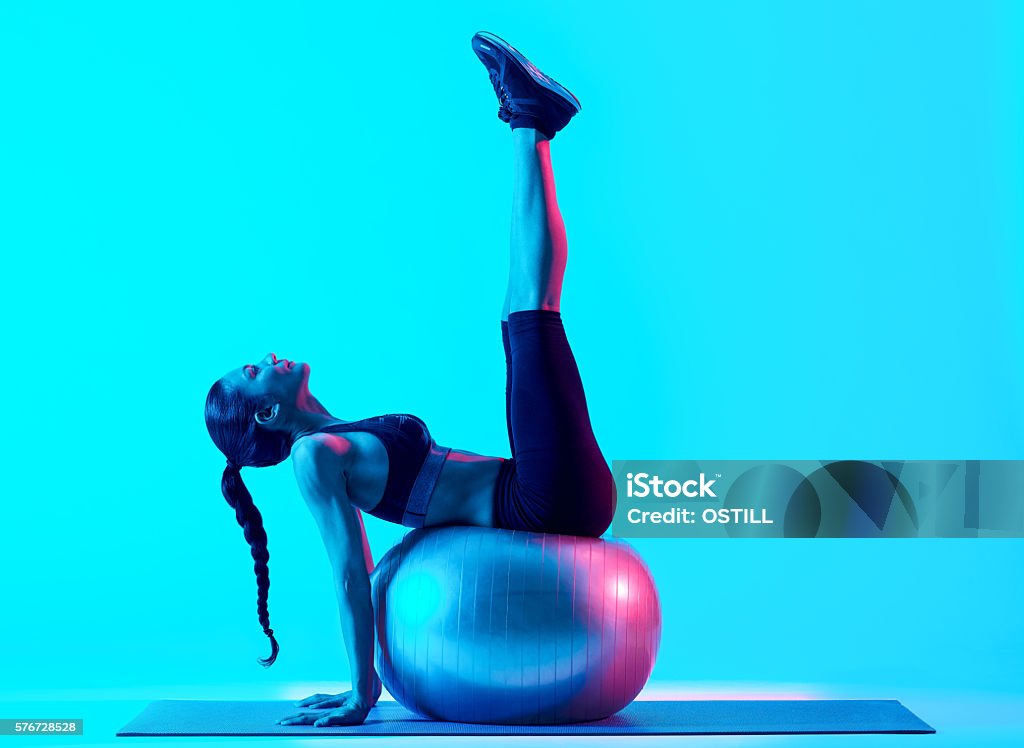 woman fitness pilates exercices isolated one mixed races woman exercsing fitness pilates exercices isolated on blue blackground Pilates Stock Photo
