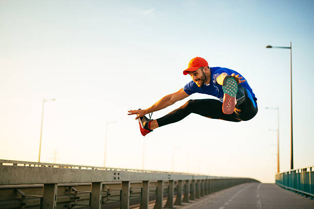 istock Muscular gymnast jumping with legs split in mid-air 576729320