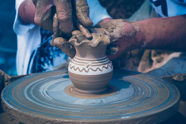 istock men's hands guiding a child's  to work with clay 576730624