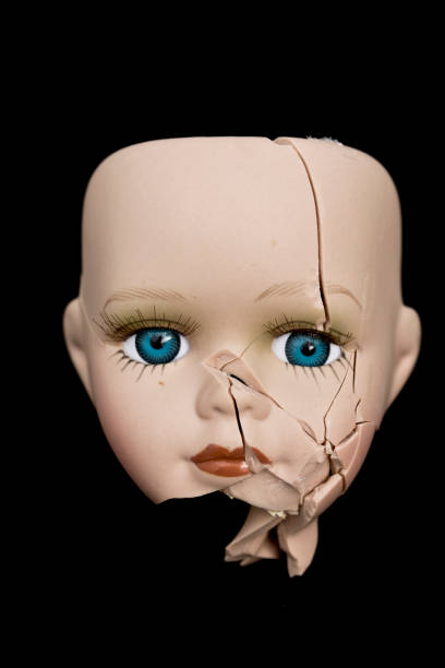 rosto de boneca quebrada e cabeça no fundo preto - doll evil child baby - fotografias e filmes do acervo