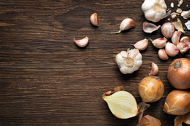 Garlic and onions Garlic cloves and onions on wooden vintage background cooking with garlic stock pictures, royalty-free photos & images