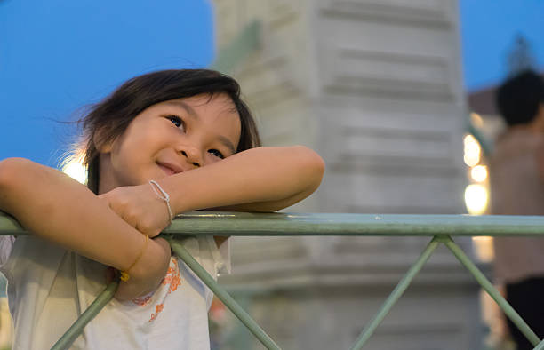 Asian girl on a bridge looking at the sky