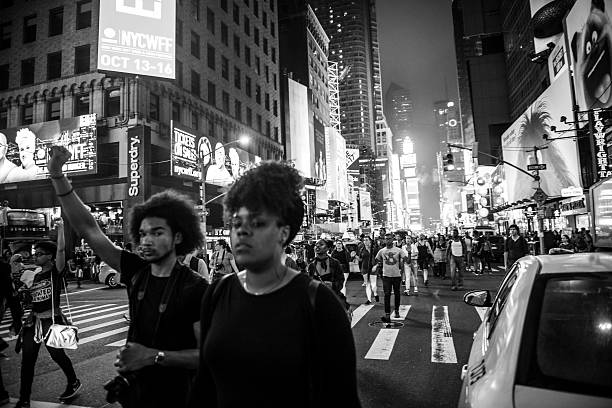 Black Lives Matter protest in Times Square, New York City New York City, USA - July 9, 2016: Black Lives Matter protestors march down a street in Times Square in New York City, demonstrating against police violence. unfairness photos stock pictures, royalty-free photos & images