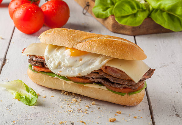 Chivito Chivito is a typical sandwich from Uruguay, with lettuce, tomato, bacon, beef, fried or boiled eggs and cheese. cedar waxwing stock pictures, royalty-free photos & images