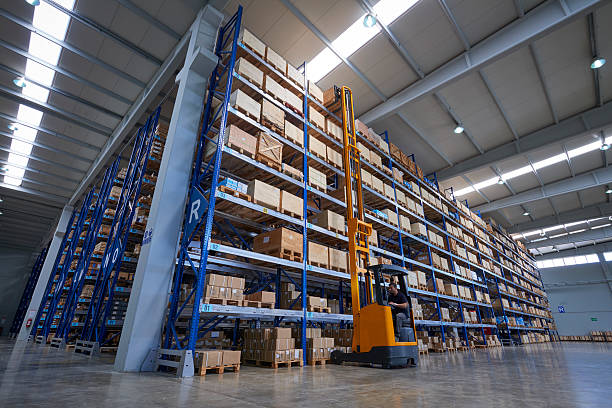 istock Forklift Lifting a cardboard box in warehouse aisle 576741194