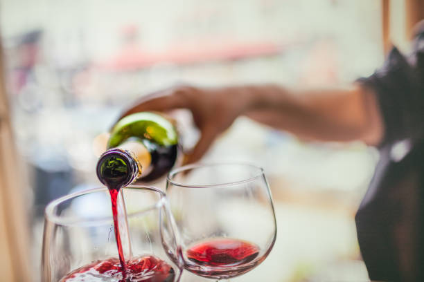 istock Pouring red wine in glasses 576747274