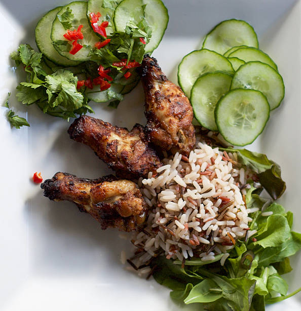 istock chicken legs served with wild rice and salad 576747500