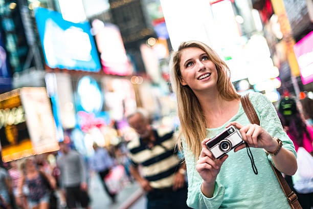 pretty woman smiling on times square with camera