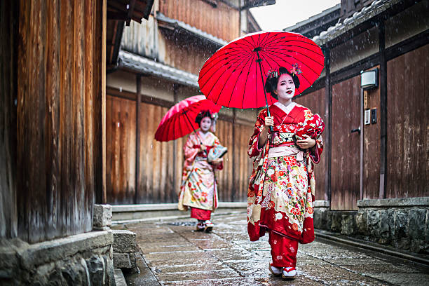 Maikos walking in the streets of Kyoto Maikos walking on a rainy day in the streets of Gion,Kyoto. kimino stock pictures, royalty-free photos & images
