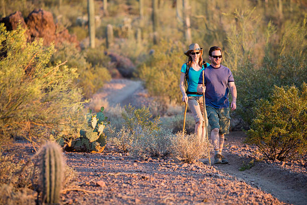 Two Afternoon Hikers on Rugged Desert Trail stock photo