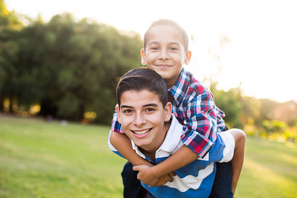 istock Teen boy carrying younger brother on back 576752992