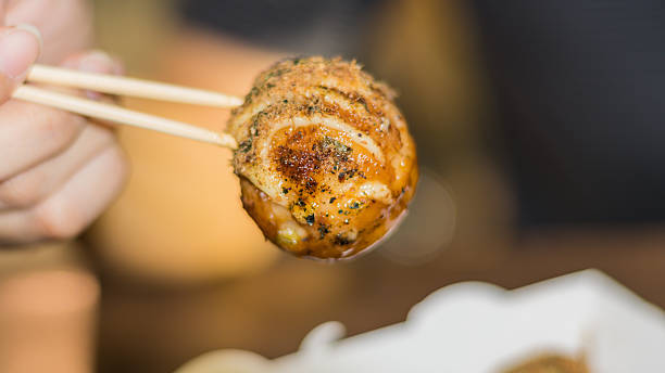 Takoyaki, delicious Japanese style octopus pancake, Takoyaki, delicious Japanese style octopus pancake, topping with multiple seasoning, very famous for snack time. cooking takoyaki is a ball shaped japanese snack stock pictures, royalty-free photos & images
