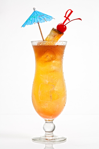 Mai Tai cocktail on white background, pineapple, cherry garnish and umbrella