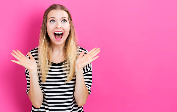istock Happy young woman posing on pink background 576755542